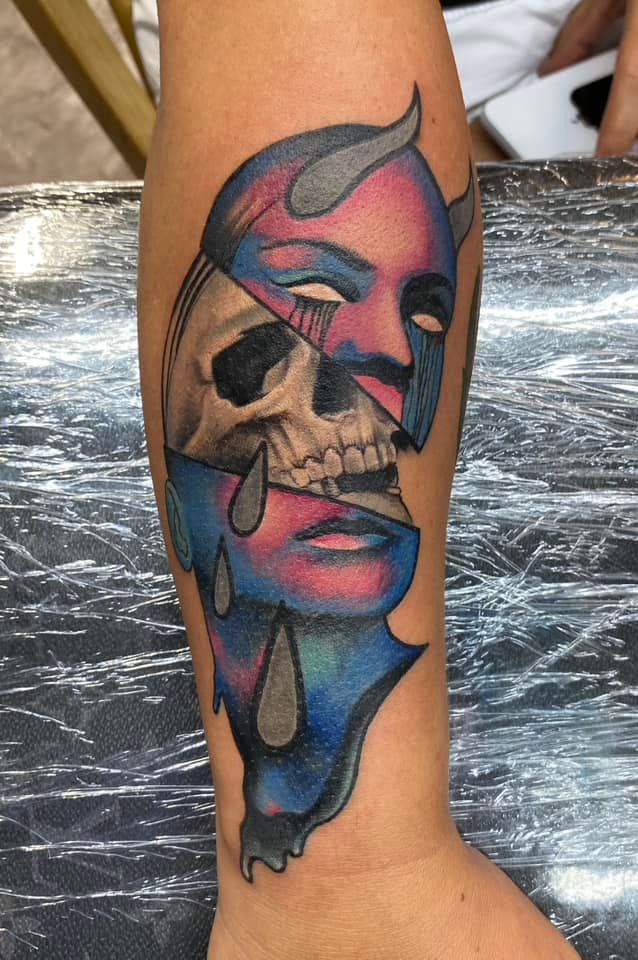 A tattoo of a woman with horns and a skull on her face