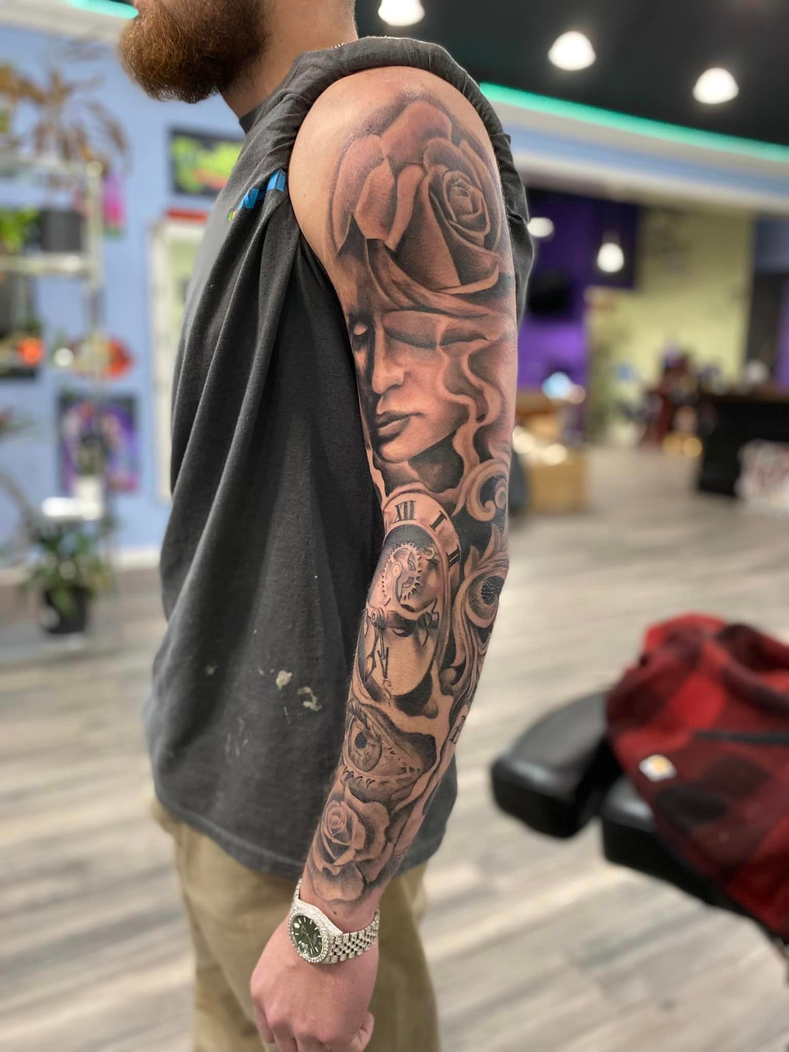 A man with a tattoo on his arm is wearing a watch.