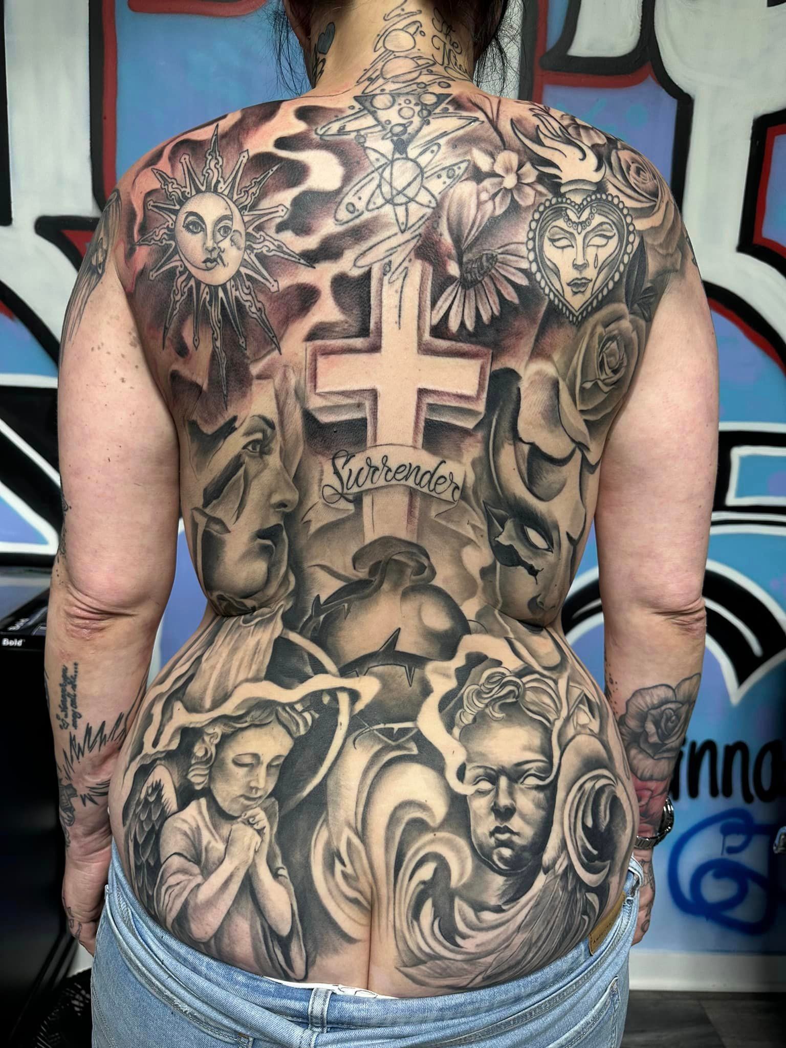 The back of a woman with a lot of tattoos on it.