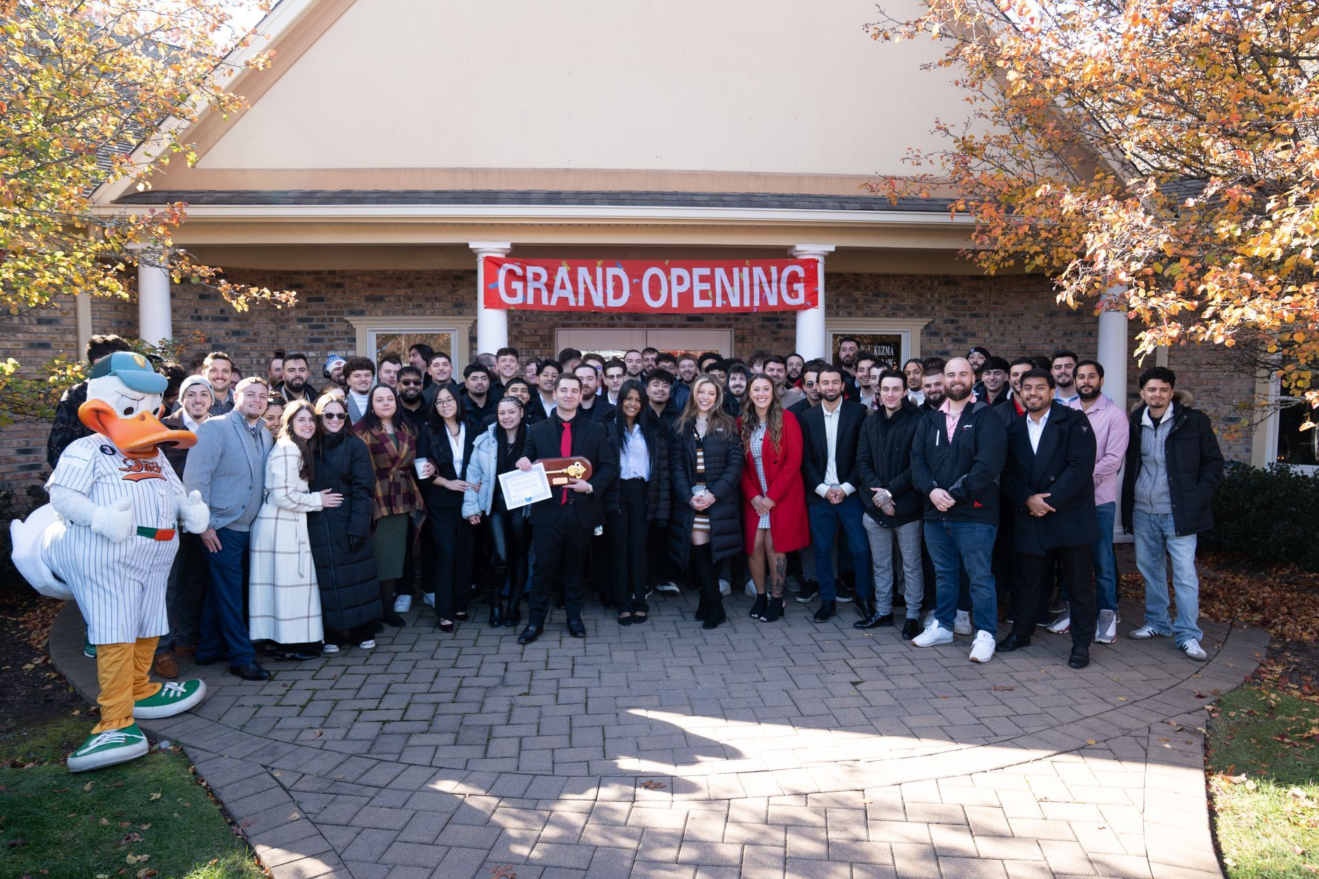 Large group of people gathered in front of a building with a 