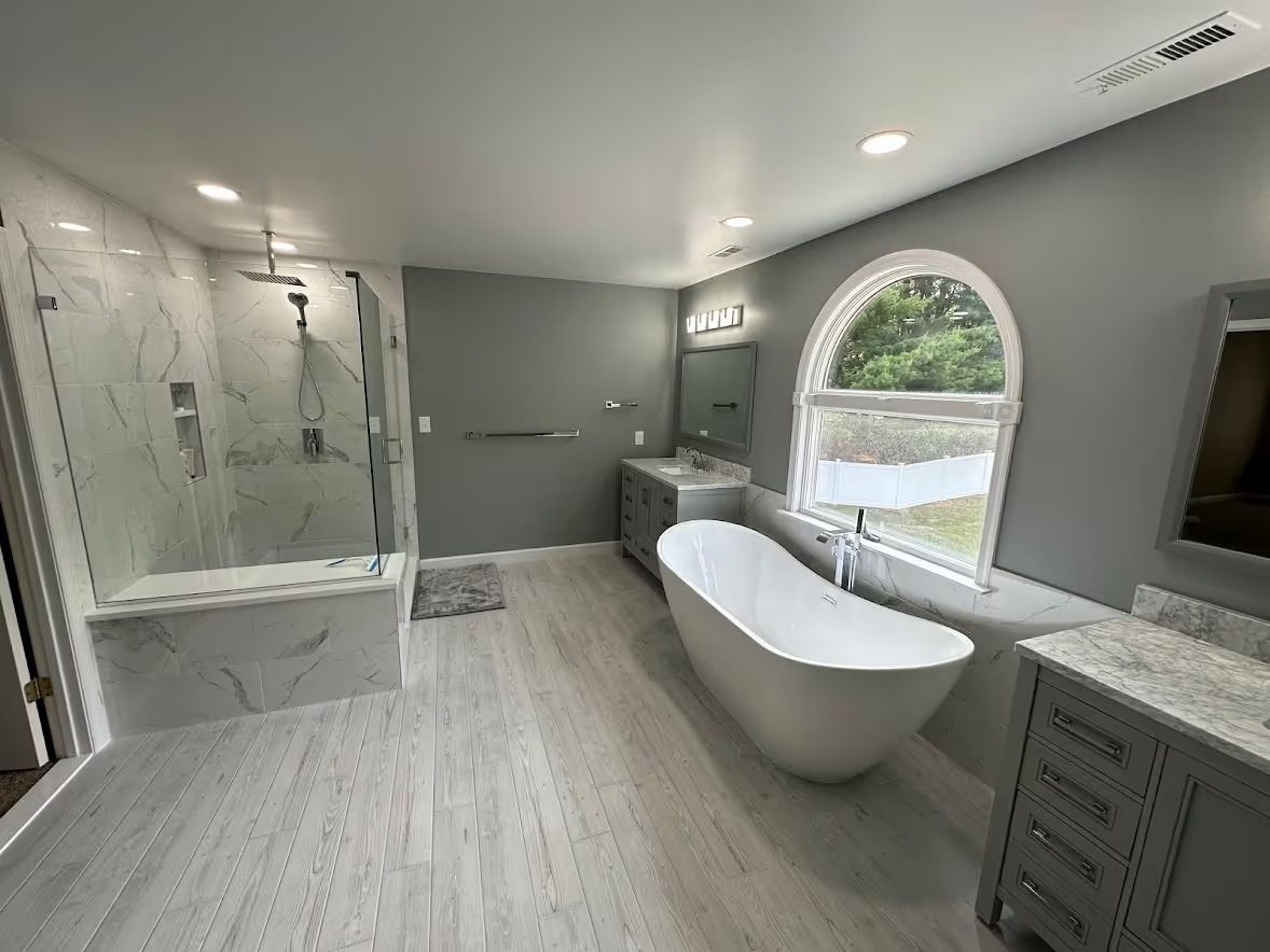 A bathroom with a tub , shower , sink and mirror.
