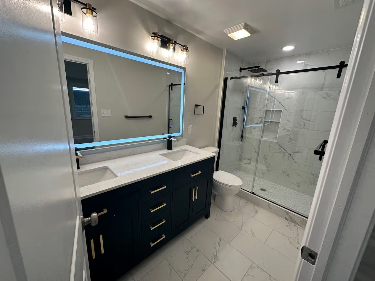 A bathroom with a walk in shower , sink , toilet and mirror.