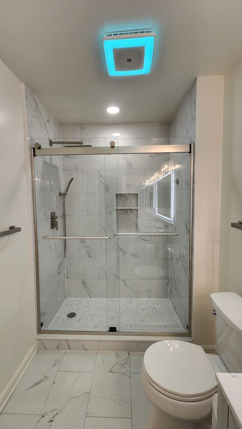 Bathroom in Sykesville with double vanity, marble-look tile floor, brushed nickel fixtures, LED mirror, and Bluetooth exhaust fan