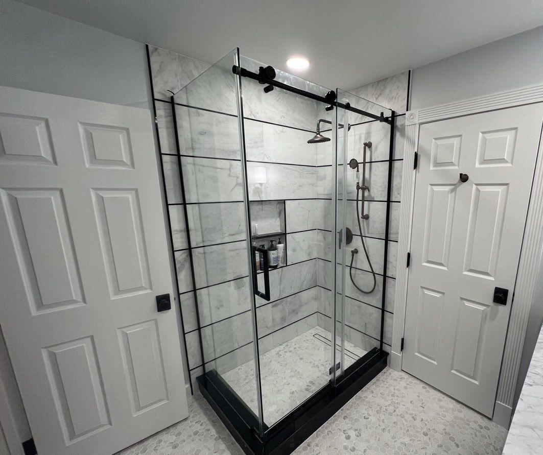 Jack and Jill bathroom in Ellicott City with full-size shower, sliding door, and marble wall and floor tiles