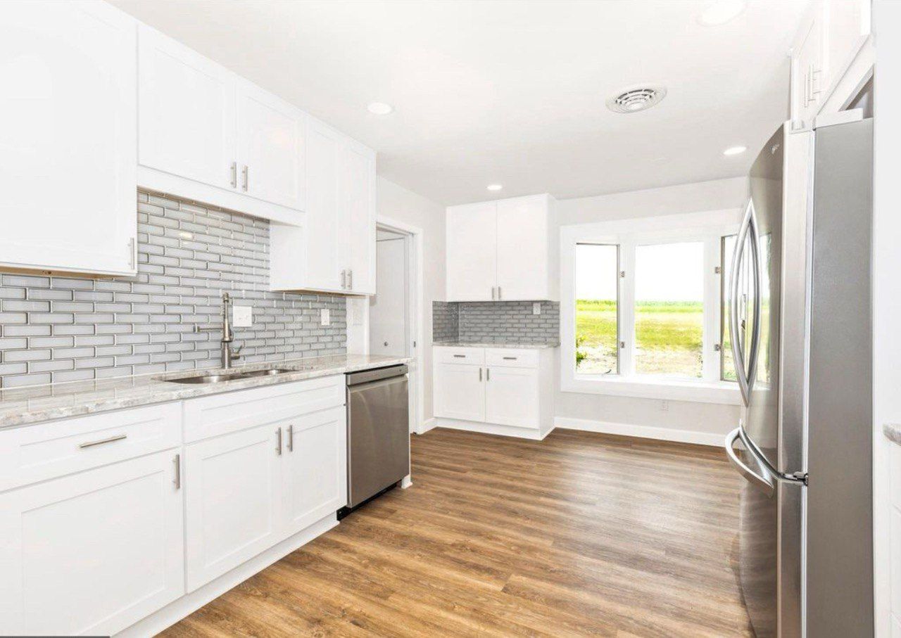 This beautiful kitchen remodel in Westminster is a complete transformation featuring 42-inch white shaker cabinets that extend to the ceiling for a clean and spacious look. The elegant granite countertops pair perfectly with the glass subway tile backsplash, while stainless steel appliances add a modern touch. The LVP flooring provides warmth and durability, and the bright recessed lighting enhances the open, inviting atmosphere. This kitchen combines timeless style with everyday functionality for a truly stunning result.