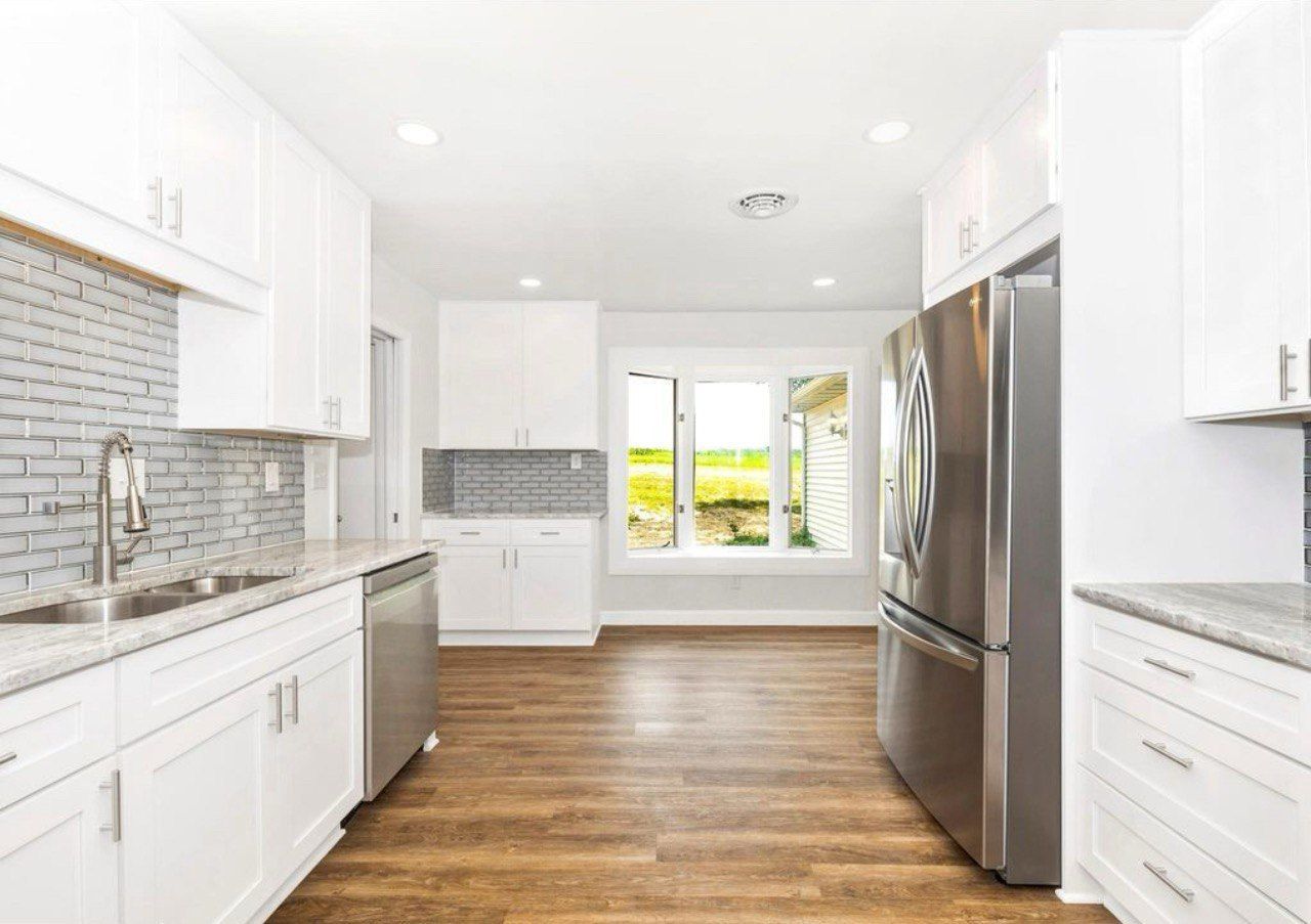 This beautiful kitchen remodel in Westminster is a complete transformation featuring 42-inch white shaker cabinets that extend to the ceiling for a clean and spacious look. The elegant granite countertops pair perfectly with the glass subway tile backsplash, while stainless steel appliances add a modern touch. The LVP flooring provides warmth and durability, and the bright recessed lighting enhances the open, inviting atmosphere. This kitchen combines timeless style with everyday functionality for a truly stunning result.