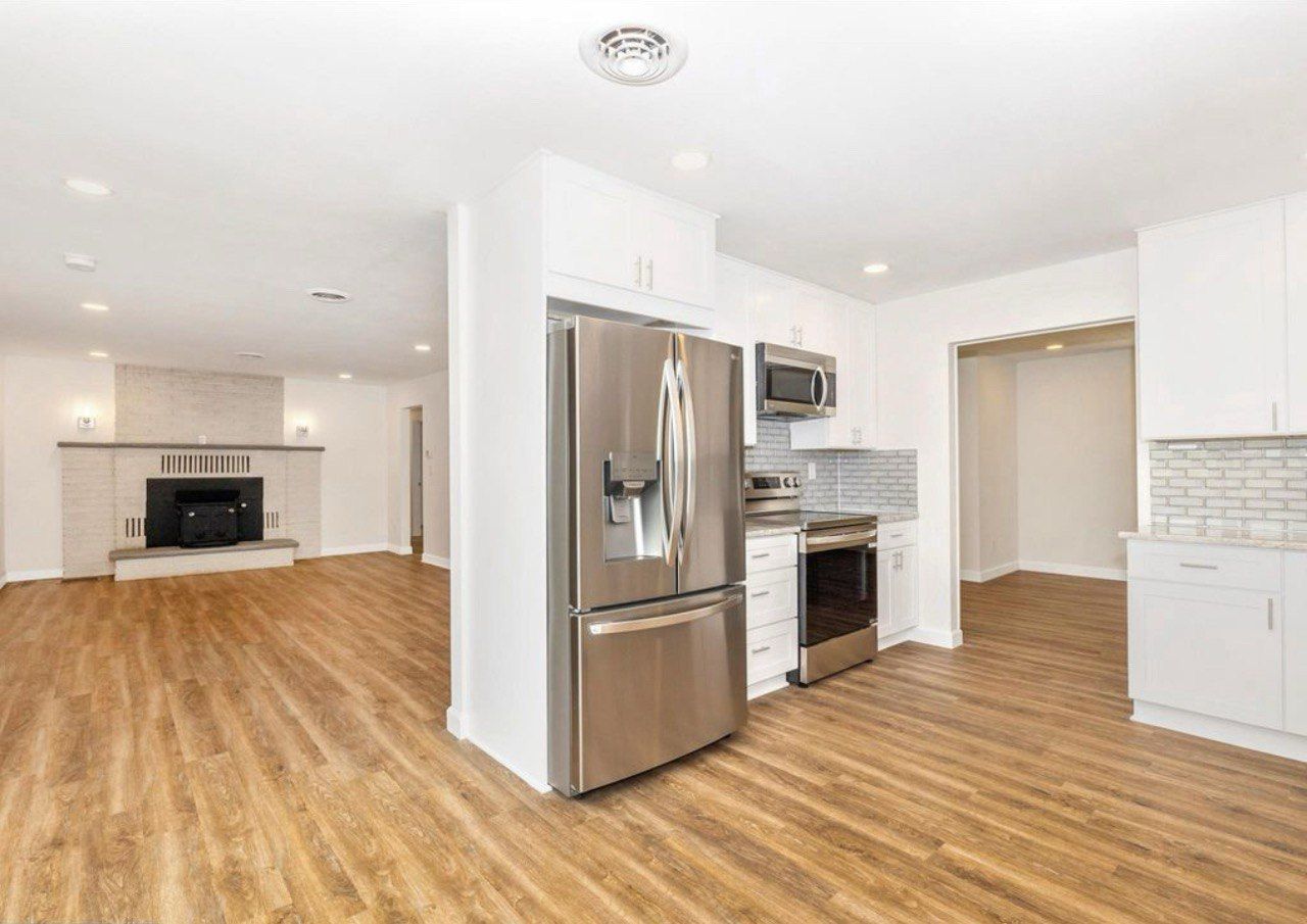 This beautiful kitchen remodel in Westminster is a complete transformation featuring 42-inch white shaker cabinets that extend to the ceiling for a clean and spacious look. The elegant granite countertops pair perfectly with the glass subway tile backsplash, while stainless steel appliances add a modern touch. The LVP flooring provides warmth and durability, and the bright recessed lighting enhances the open, inviting atmosphere. This kitchen combines timeless style with everyday functionality for a truly stunning result.