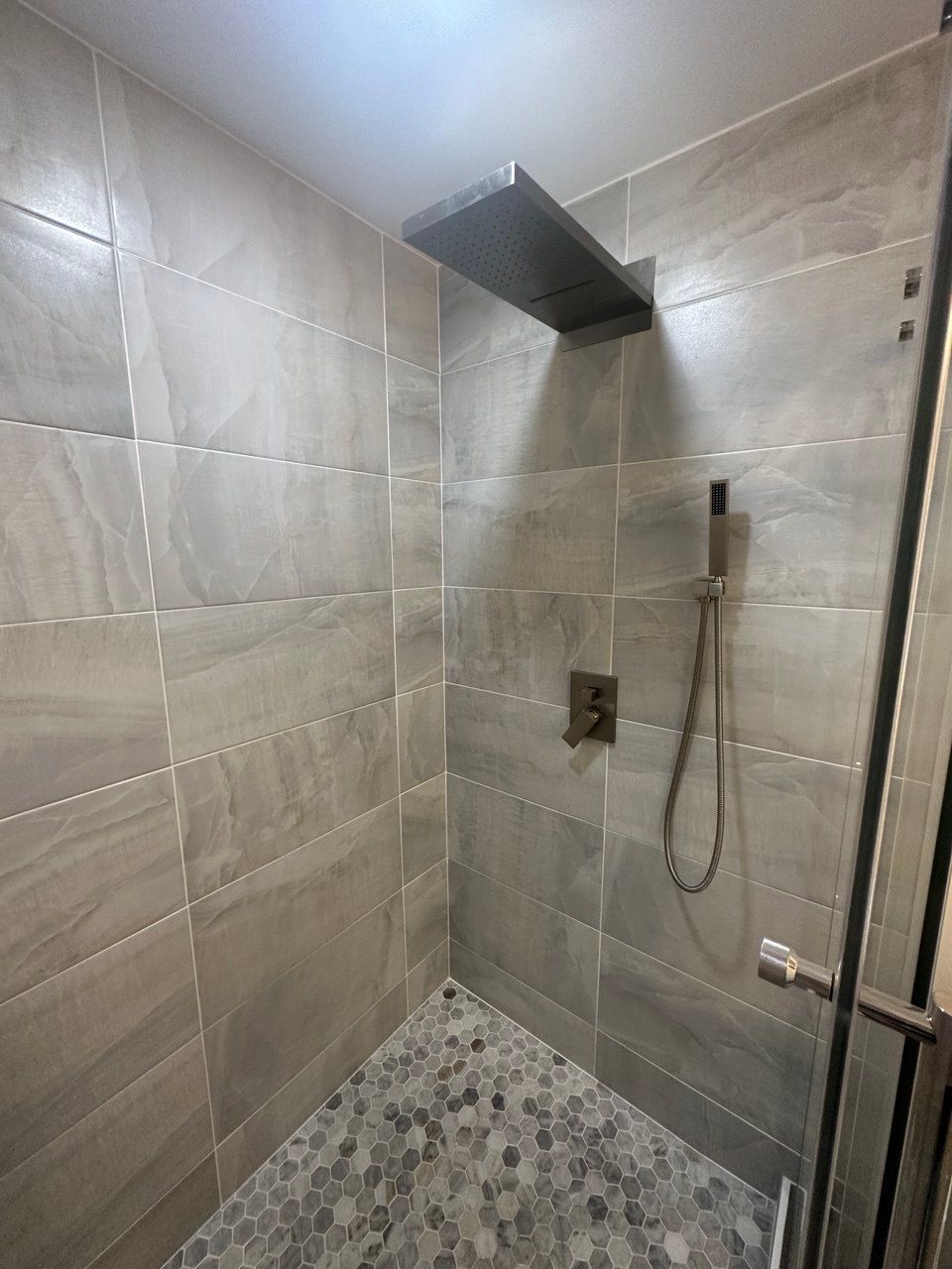 Expanded master bathroom in Finksburg with floating double vanity, LED mirror, large shower, bidet toilet, and 24x24 tile flooring