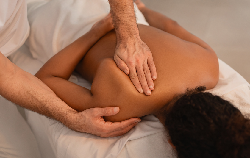 A man is giving a woman a massage on her back.