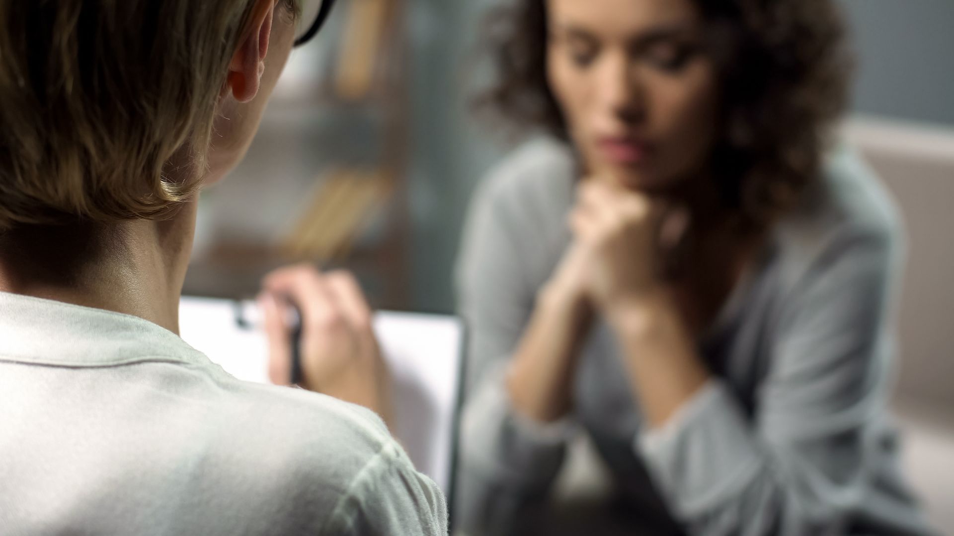 Therapist listening to an individual in distress at a professional mental health counseling center.