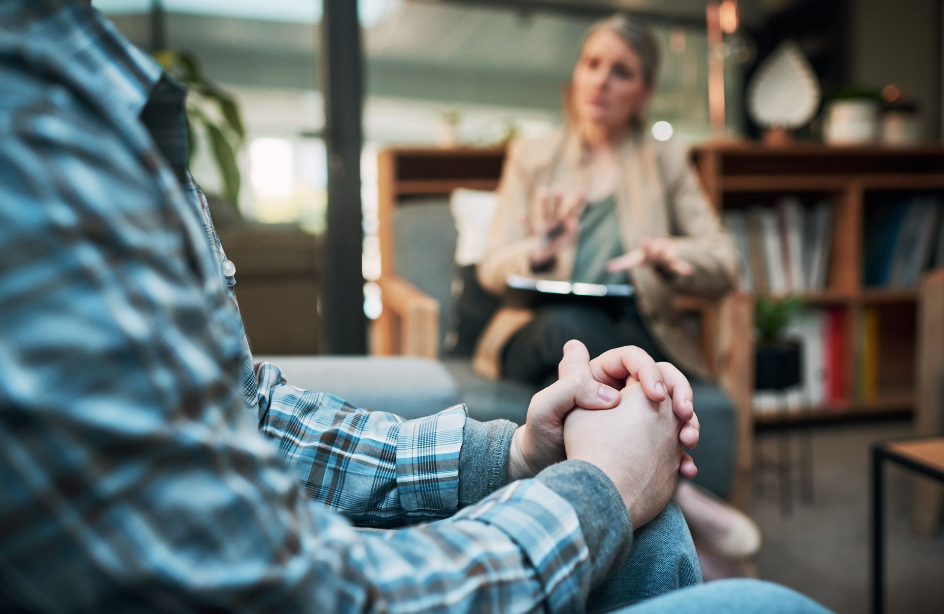 A man is holding hands with a woman while sitting on a couch.