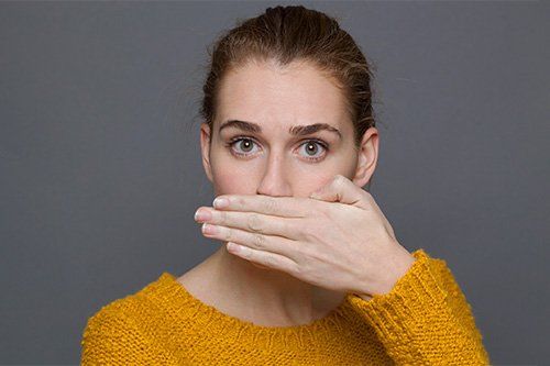 bad breath - woman covering mouth
