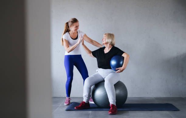 A group of older women are playing with hula hoops