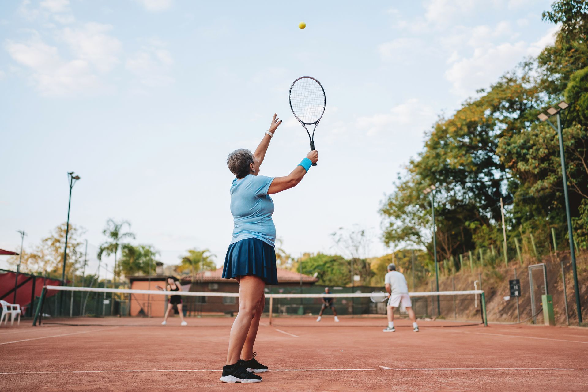 Two older women are doing yoga in a park