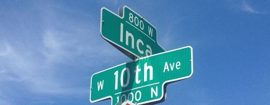 A street sign for inca and 10th ave against a blue sky