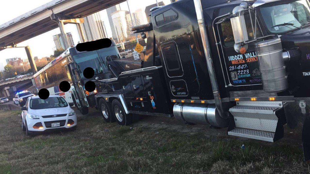 Commercial Vehicle Towing — Black Truck Towing a Bus in Houston, TX