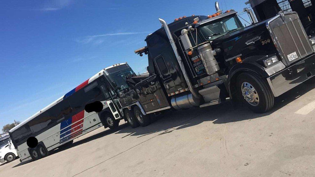 Commercial Vehicle Towing— Heady Duty Towing a White Bus in Houston, TX