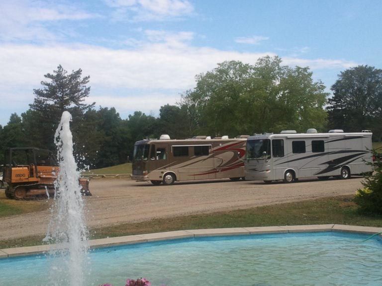 A couple of rvs parked next to a fountain