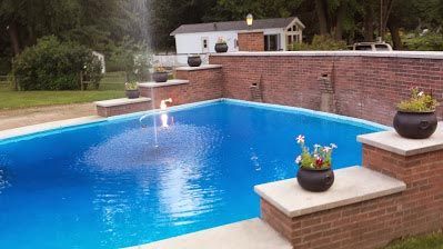 A large swimming pool with a fountain in the middle of it.