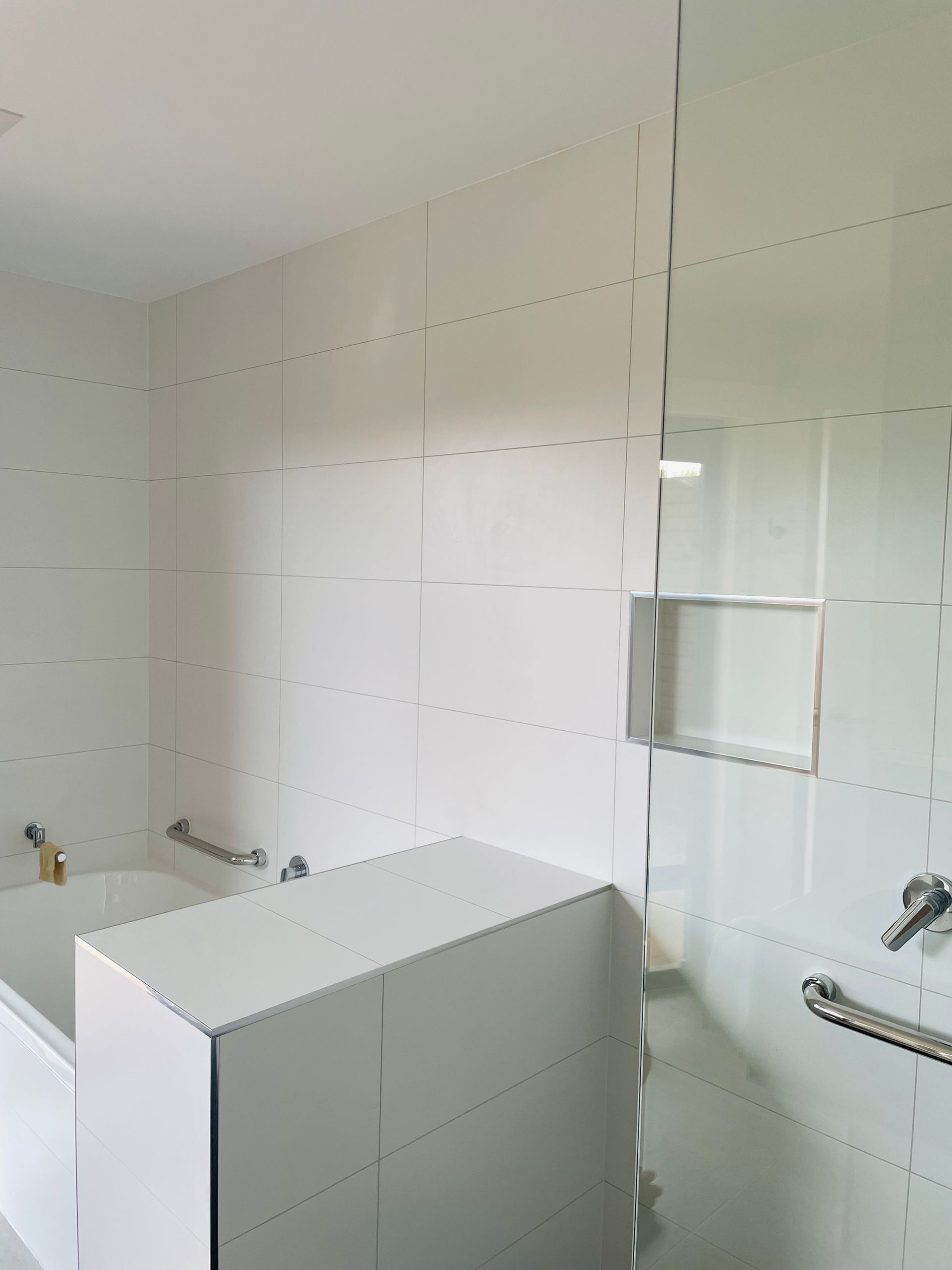 A White-tiled Bathroom Featuring a Bathtub, a Tiled Half-wall — Hobart Tiling Solutions In Clarendon Vale, TAS