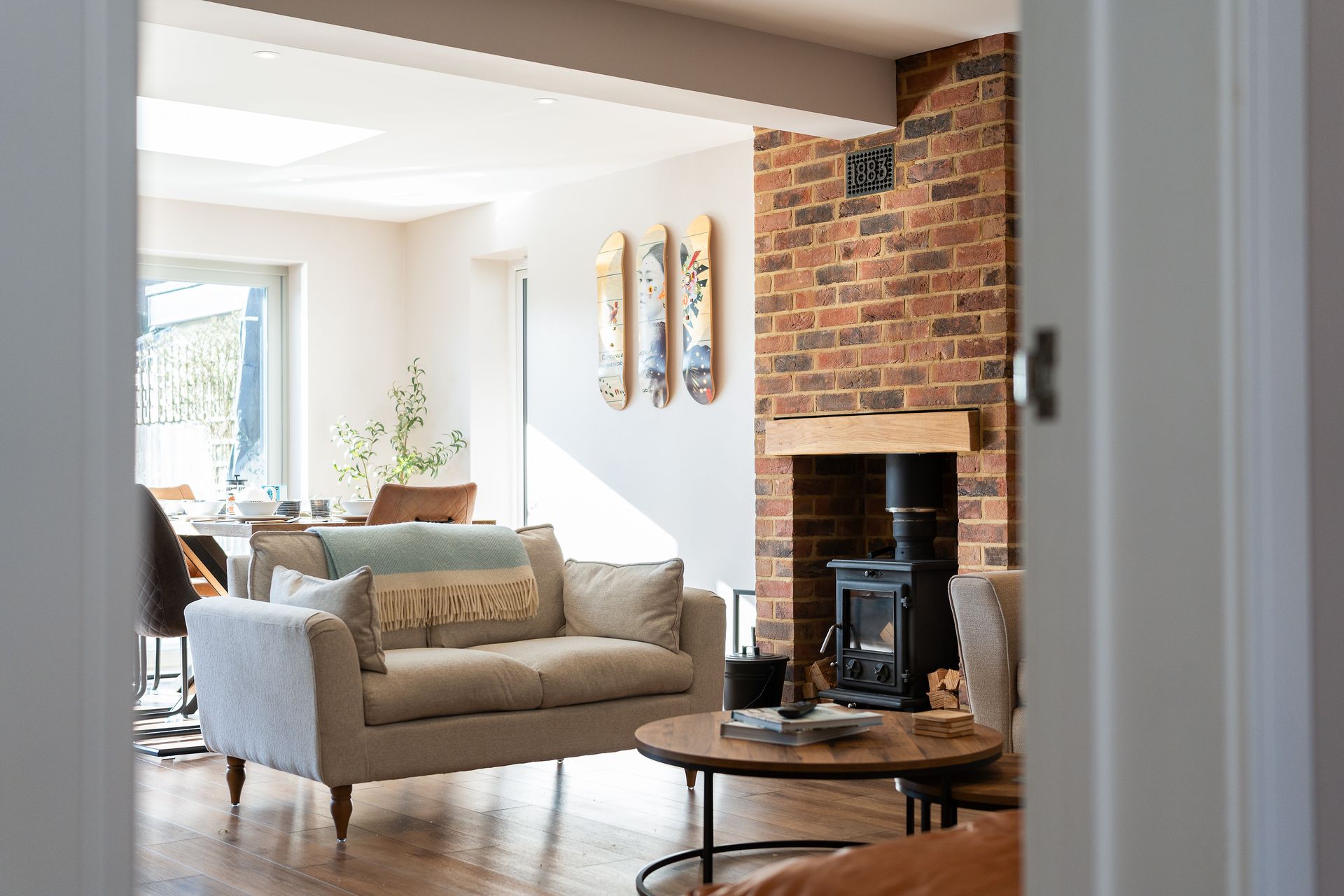 A living room with a couch , fireplace , table and chairs.
