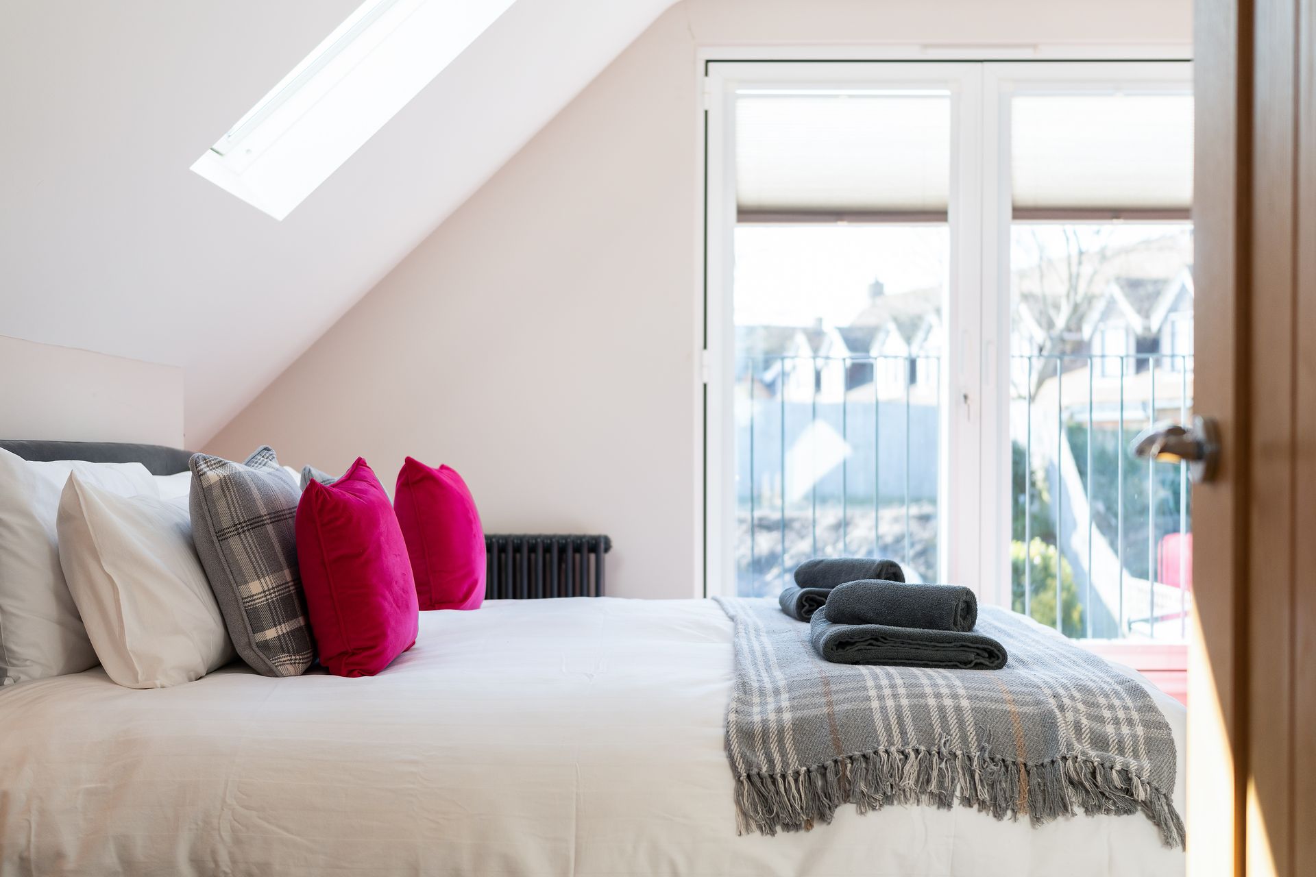 A bedroom with a king size bed and a balcony.