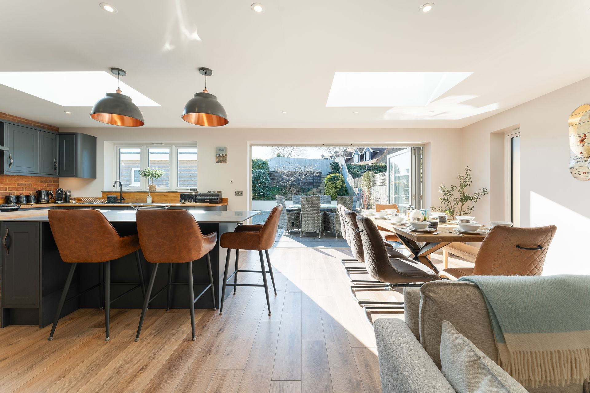 A living room with a dining table and chairs and a kitchen.