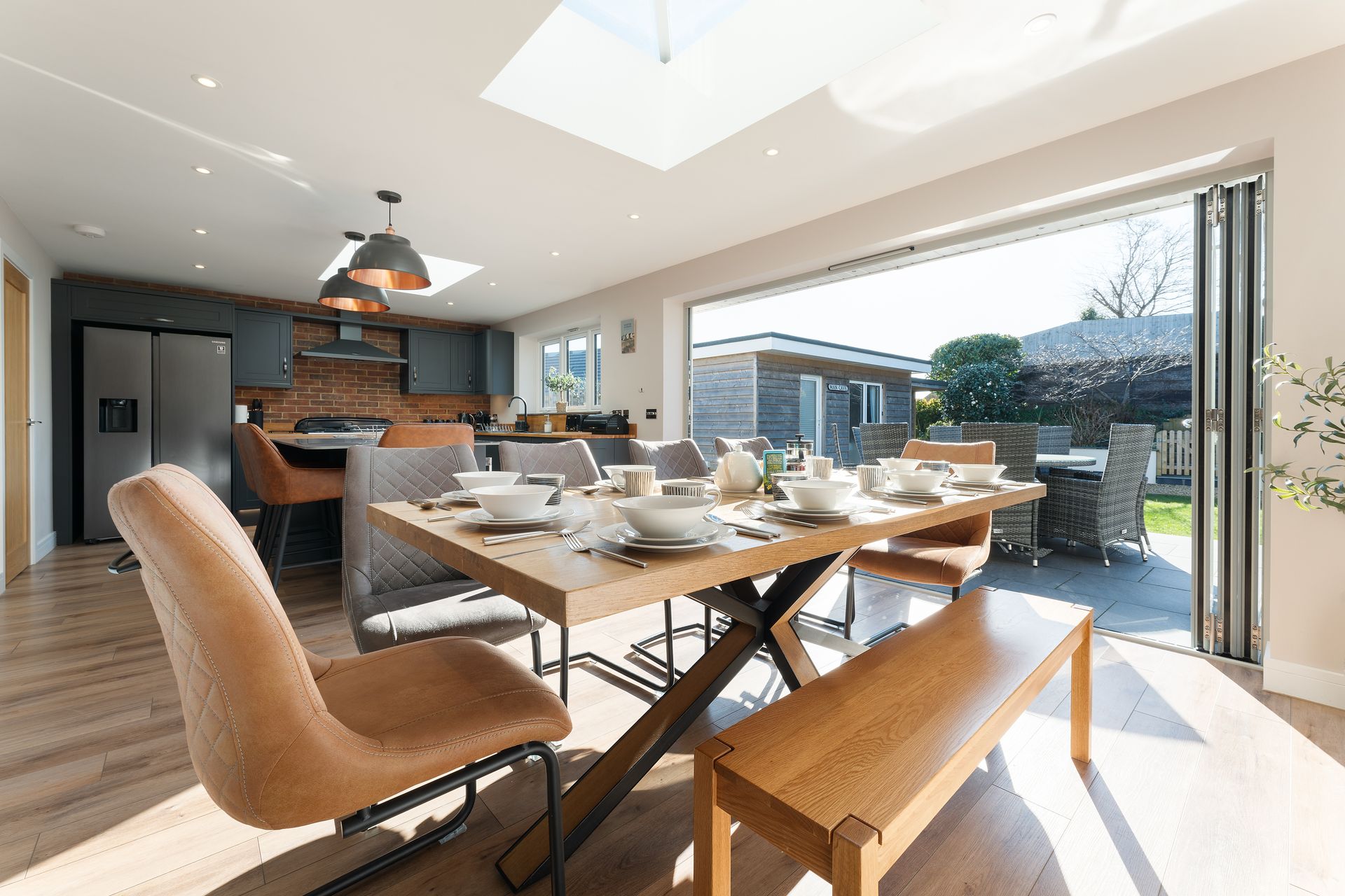 A dining room with a table and chairs and a bench.