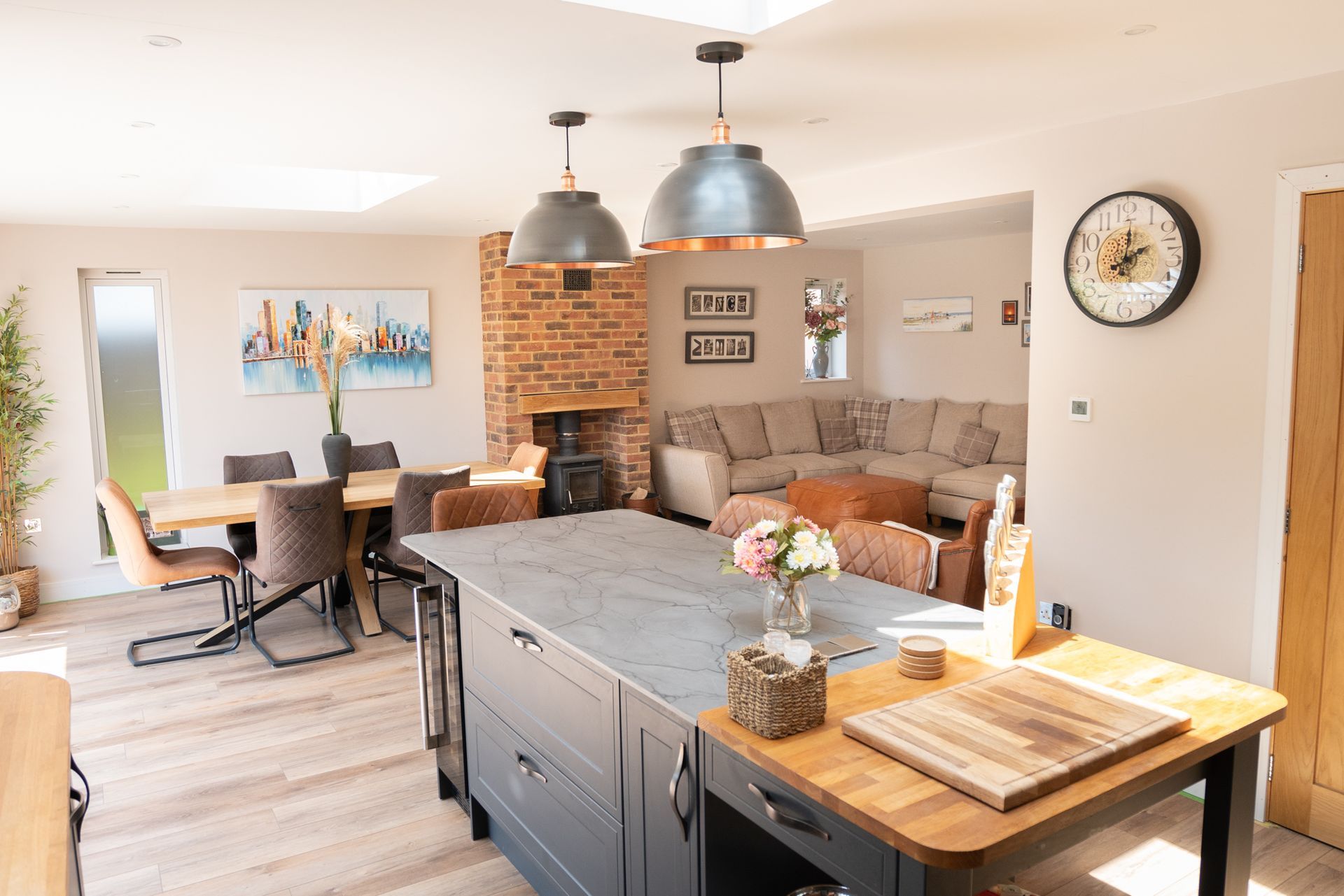 A kitchen with a large island and a clock on the wall.