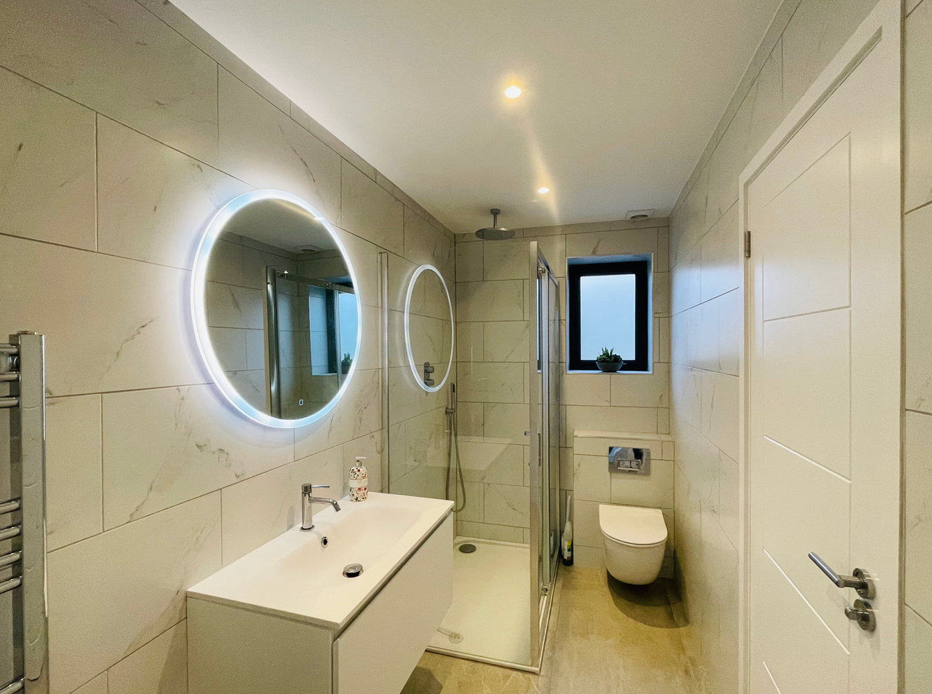 A bathroom with a sink , toilet , shower and mirror.
