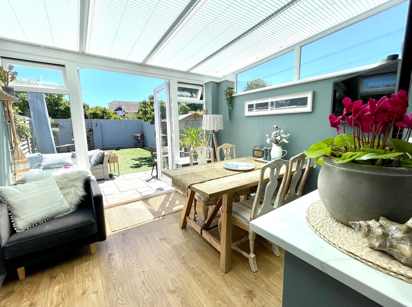 A living room with a table and chairs and a potted plant.