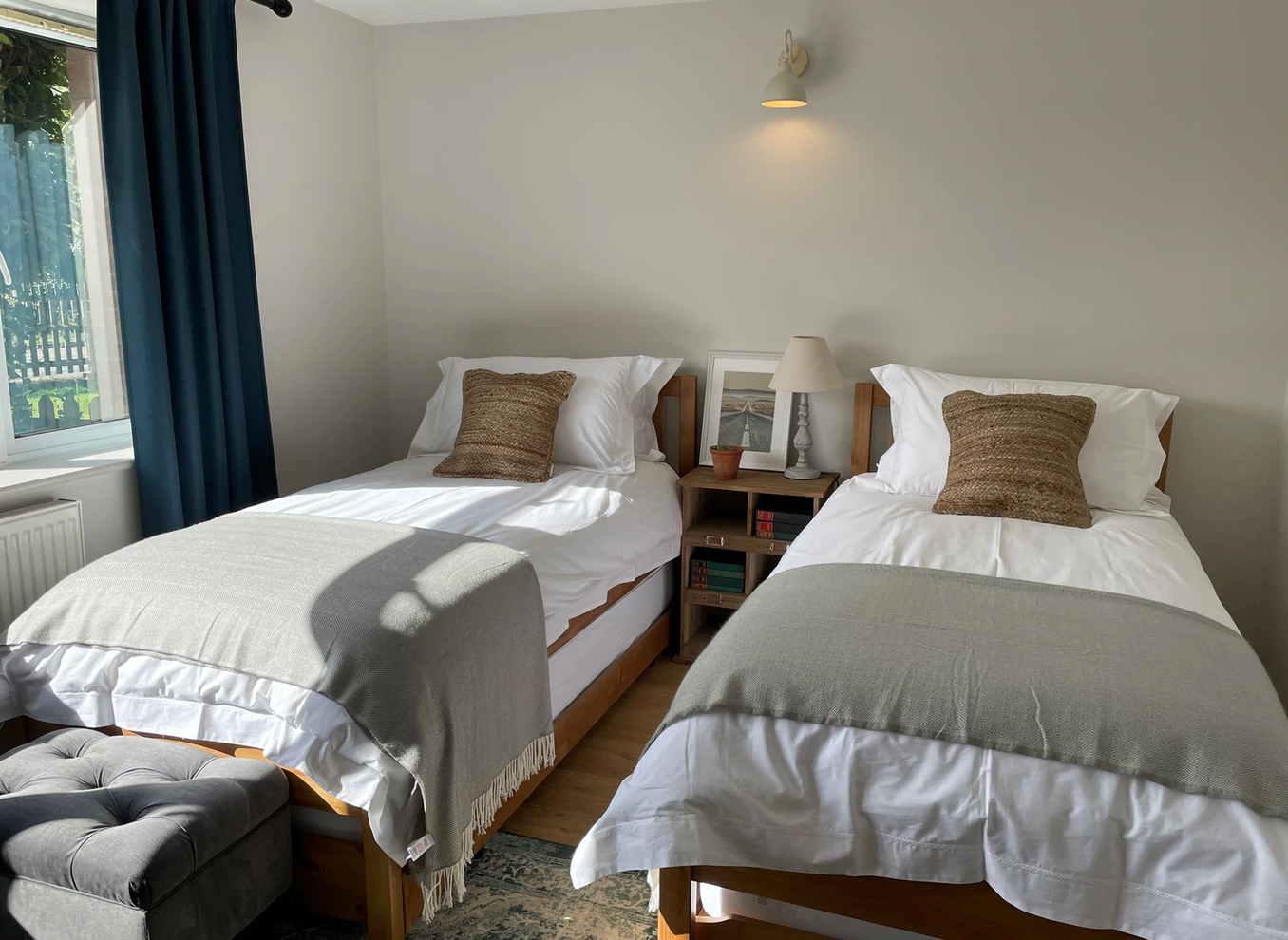 A bedroom with two twin beds and a window.