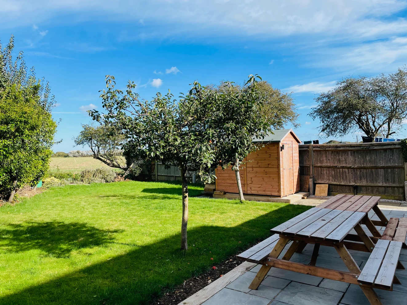 A picnic table is sitting in the middle of a lush green yard.