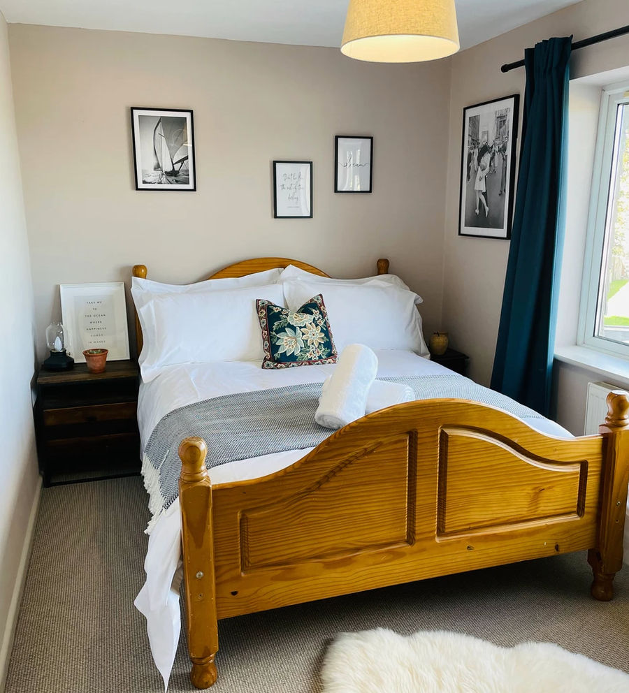 A bedroom with a wooden bed and a window