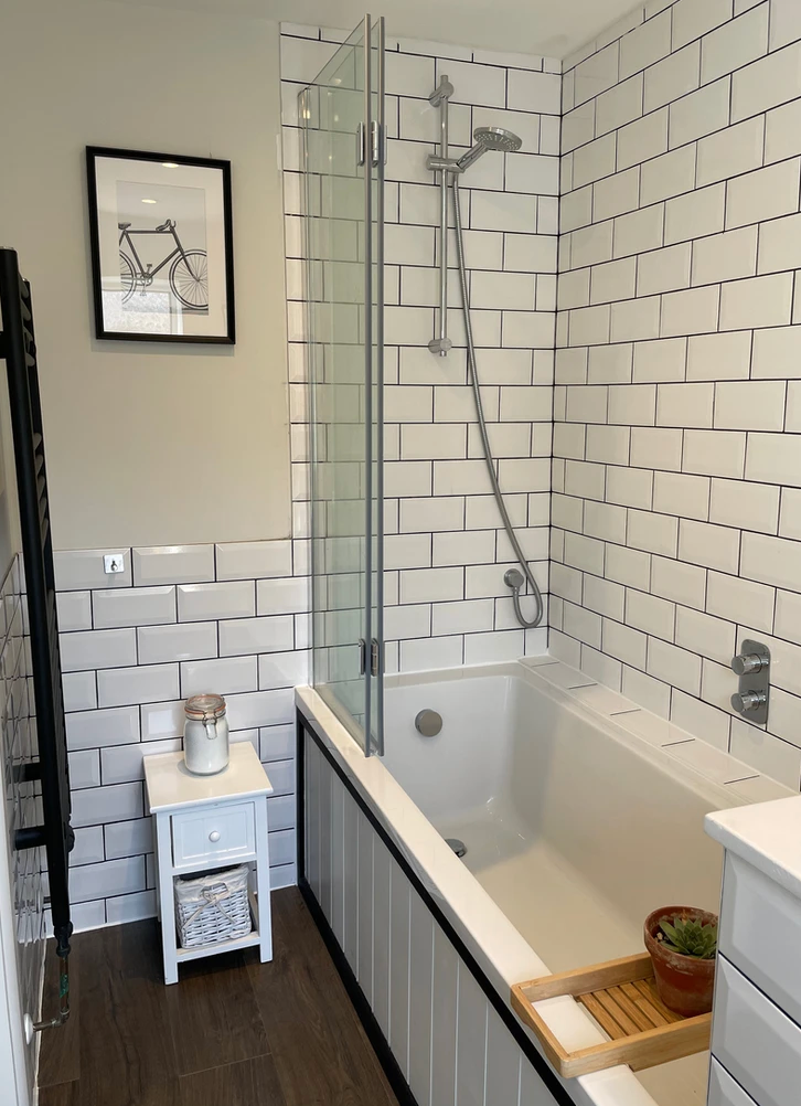 A bathroom with white subway tiles and a bathtub