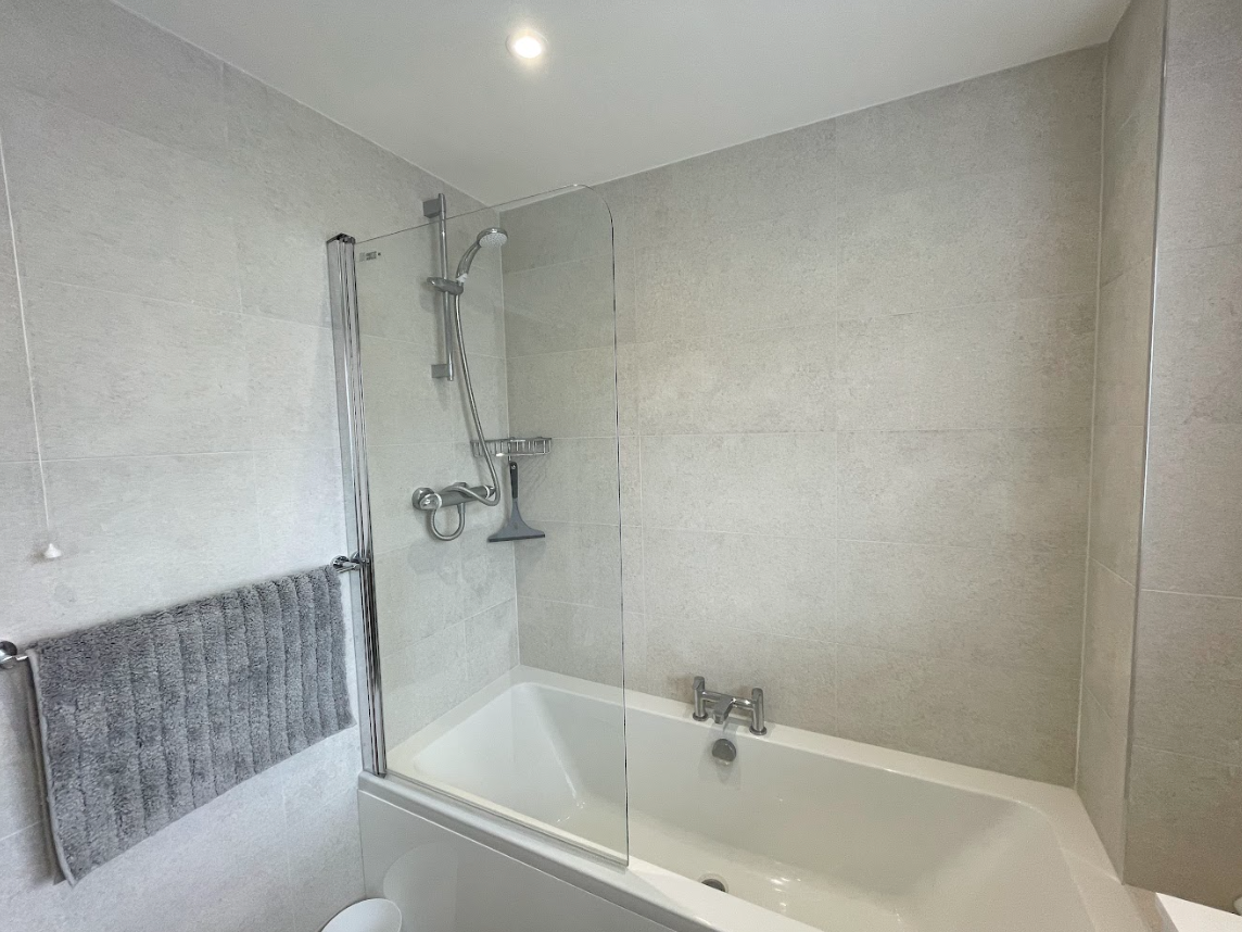 A bathroom with a bathtub and a shower stall.