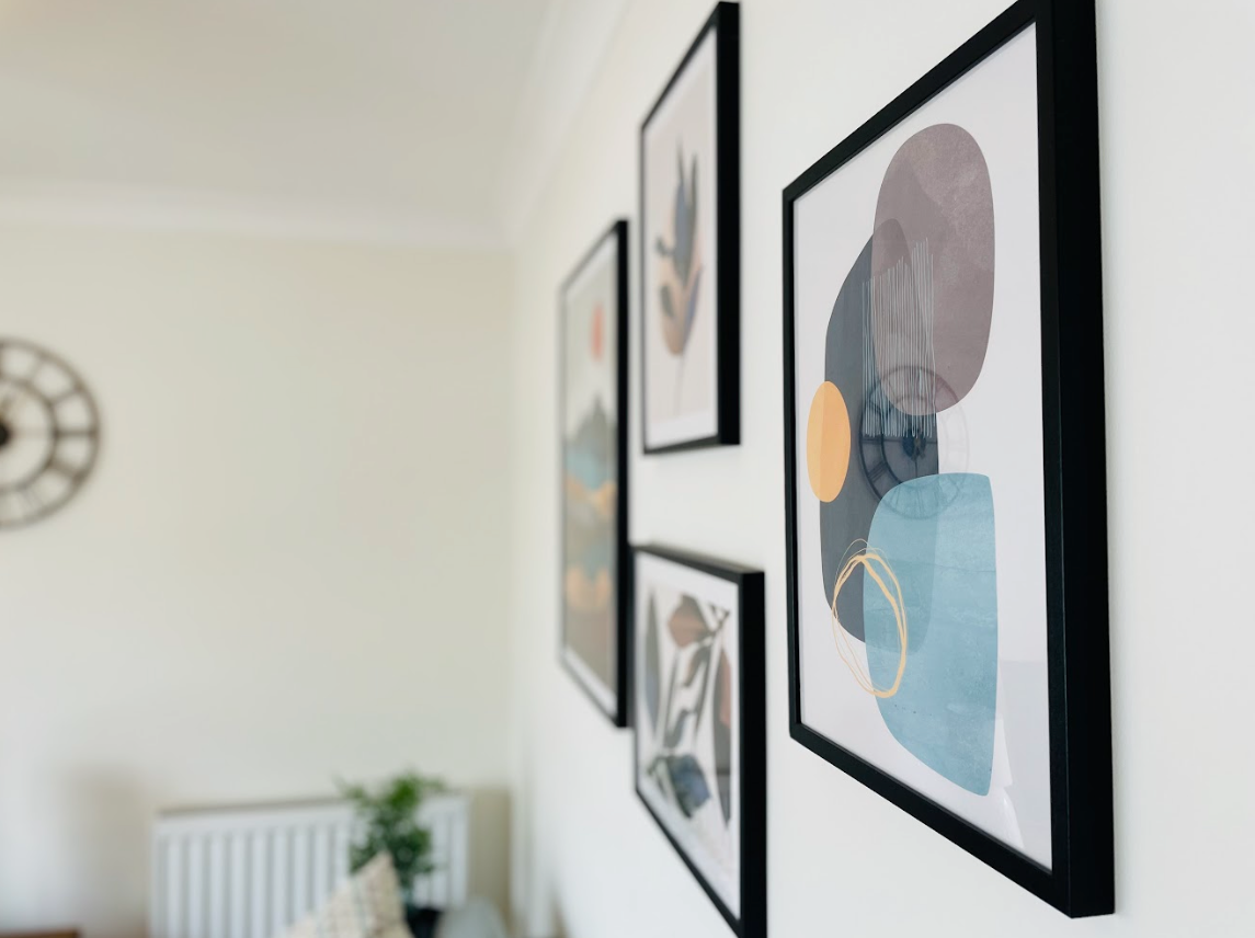 A room with a clock on the wall and a bunch of pictures on the wall