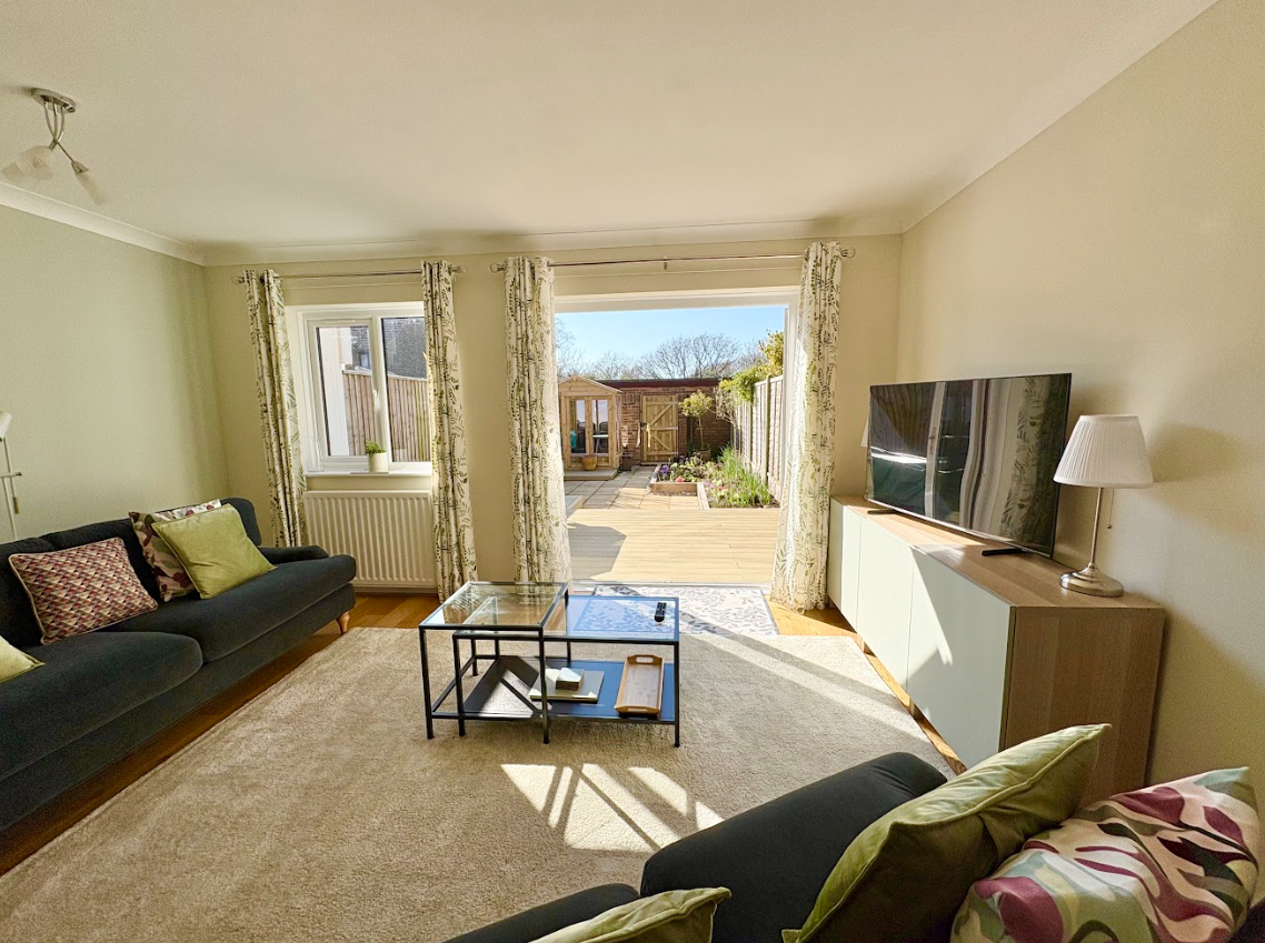 A living room with two couches , a coffee table , and a television.