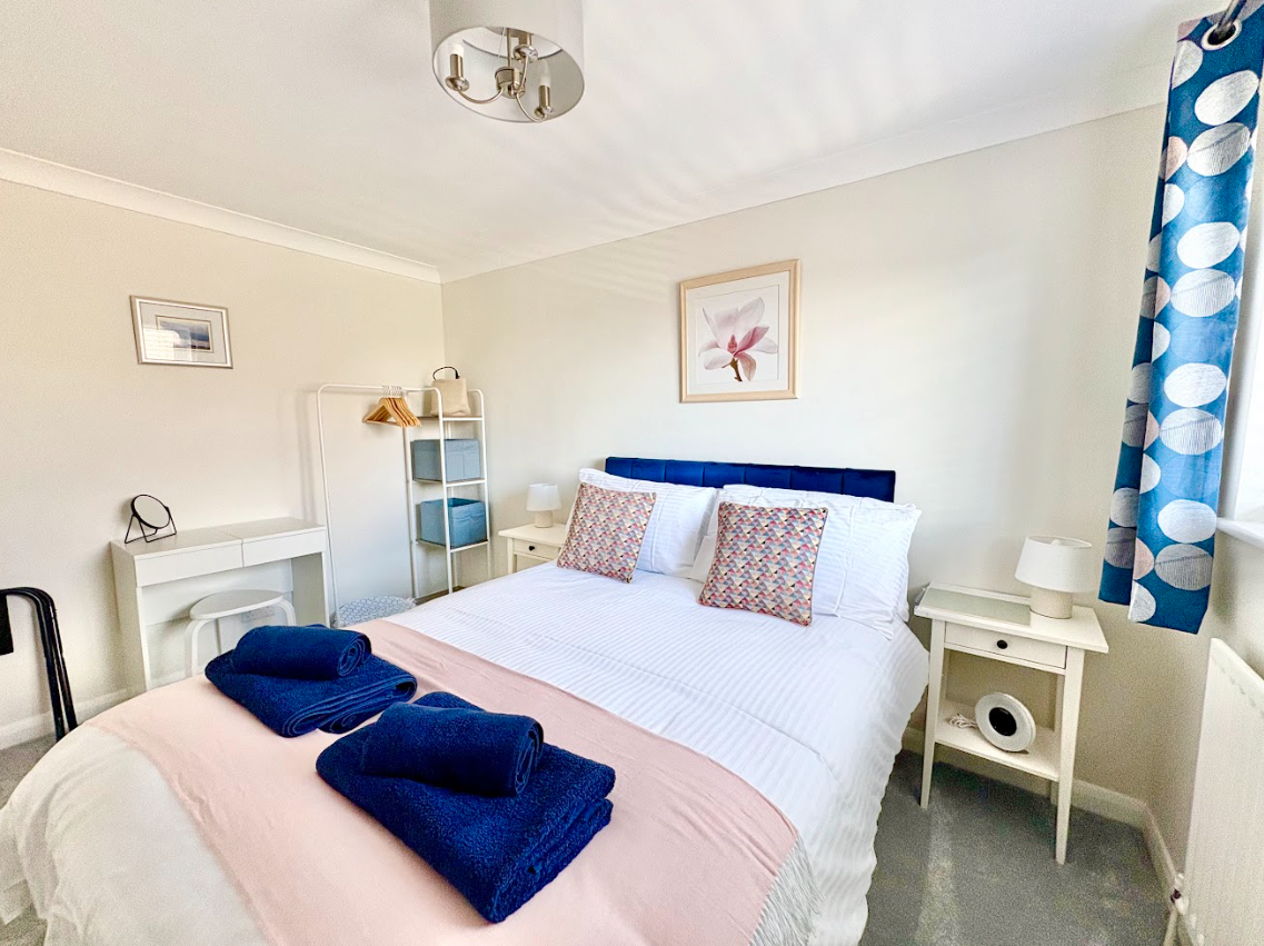 A bedroom with a king size bed , nightstand , and dresser.