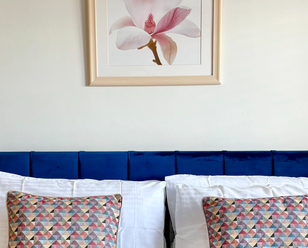 There is a picture of a flower on the wall above the bed.