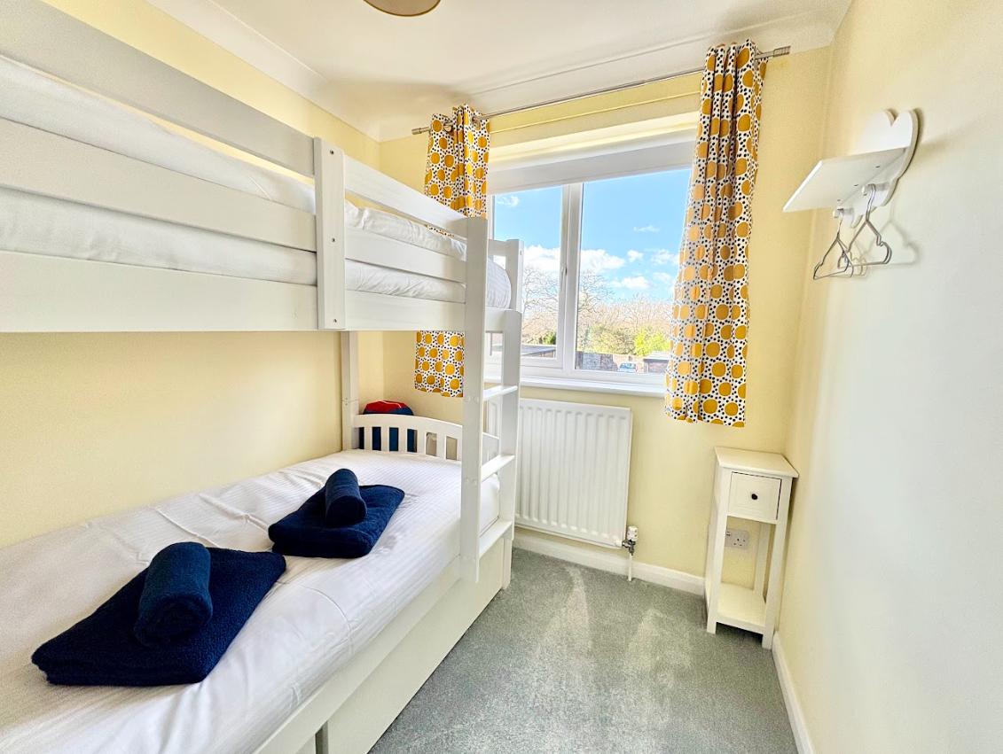 A bedroom with two bunk beds and a window.