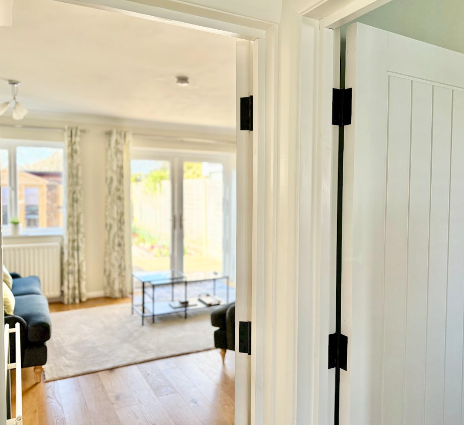 A living room with a couch , chair , table and sliding glass doors.