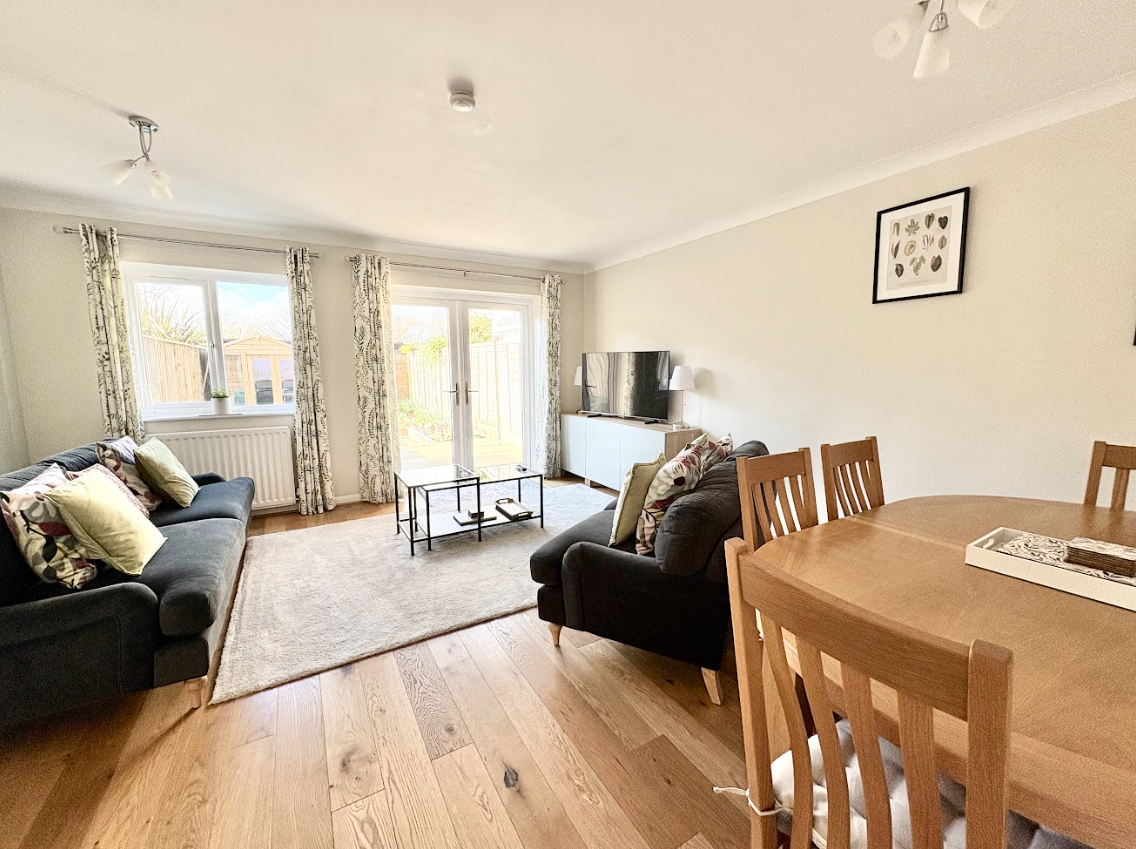 A living room with a couch , table and chairs.