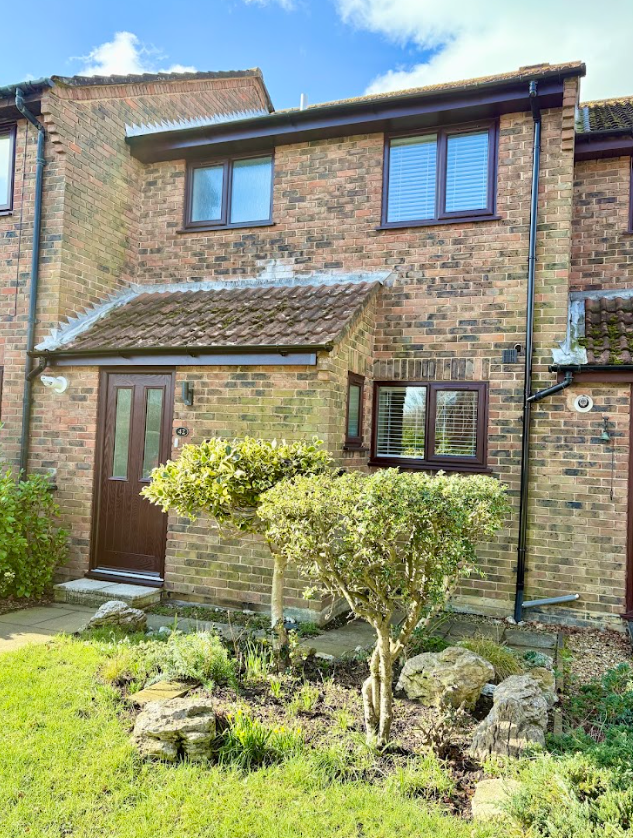A brick house with a garden in front of it.