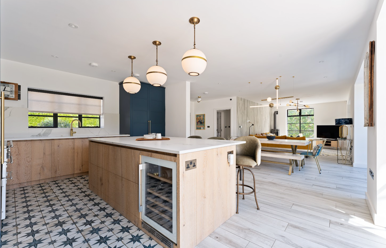 A kitchen with a large island and a wine cooler.