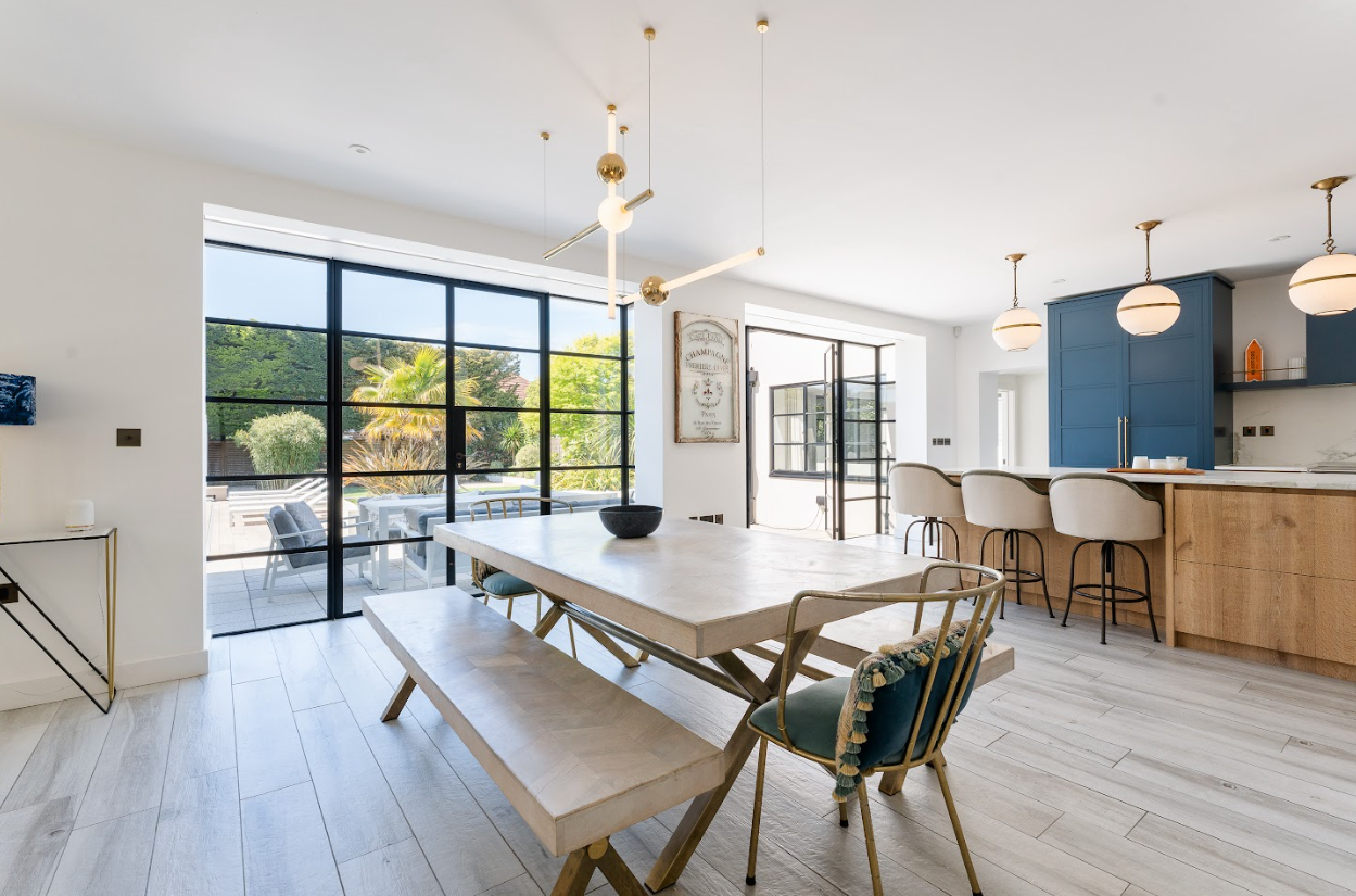 A dining room with a table and chairs and a bench.