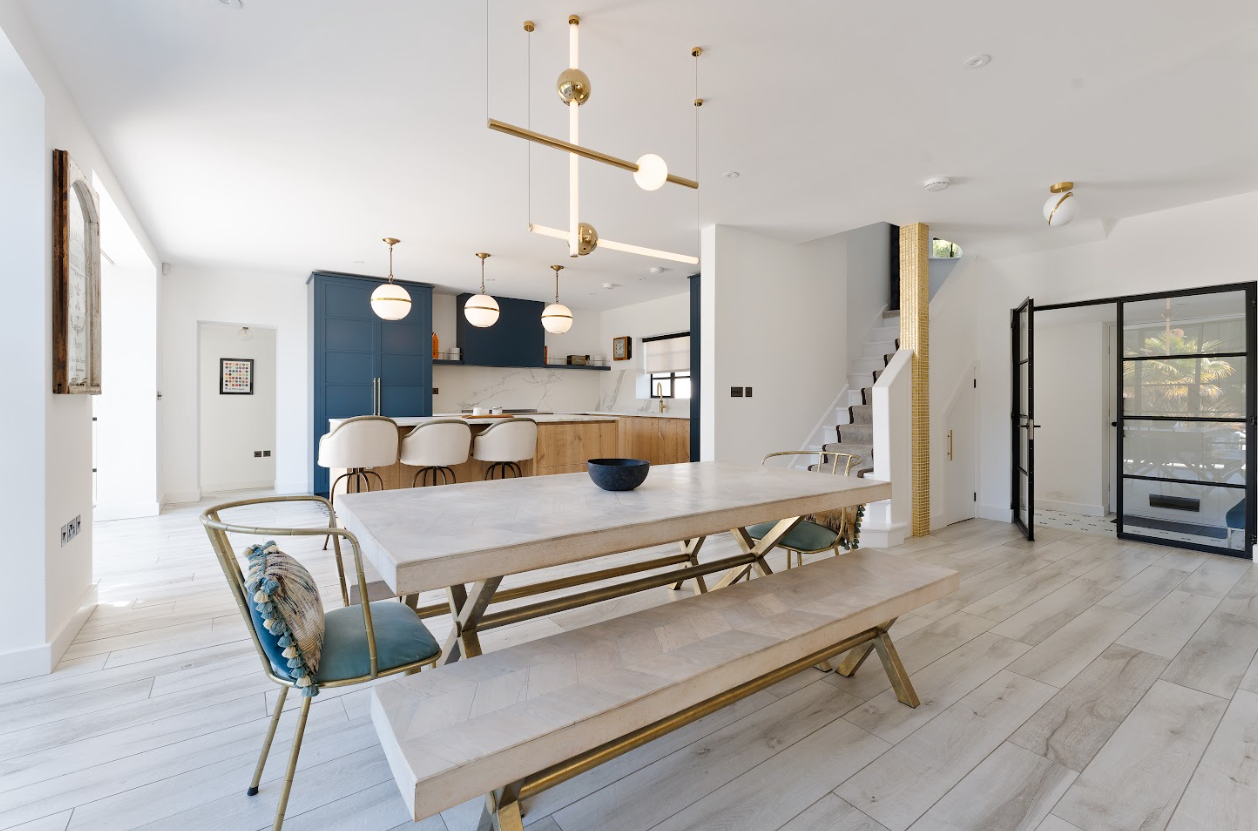 A dining room with a table and chairs and a bench.