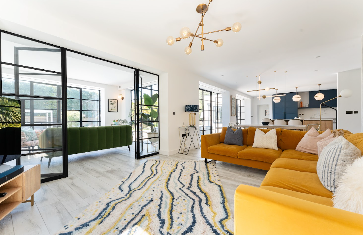 A living room with a yellow couch and a rug.