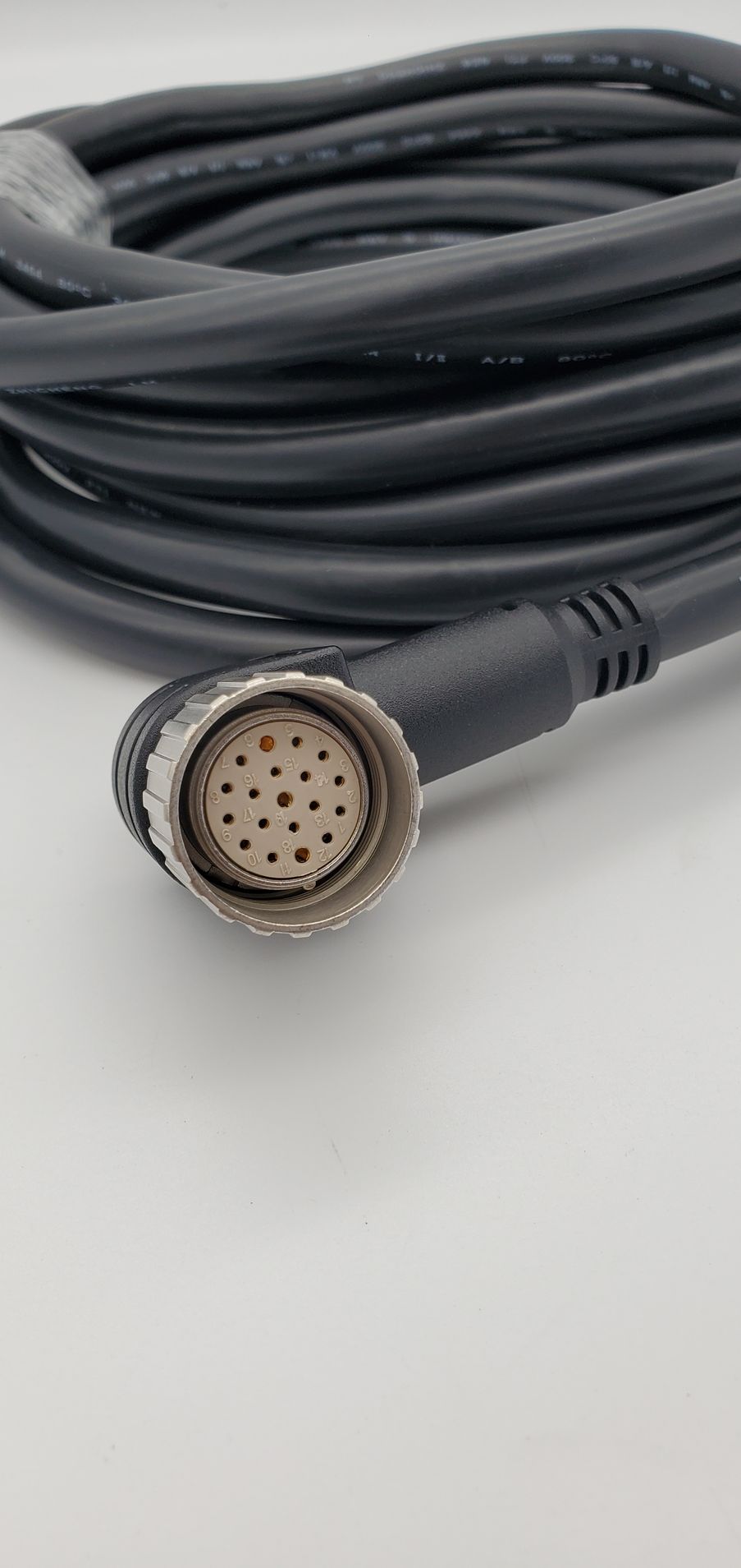 A close up of a cable with a connector on a white surface.
