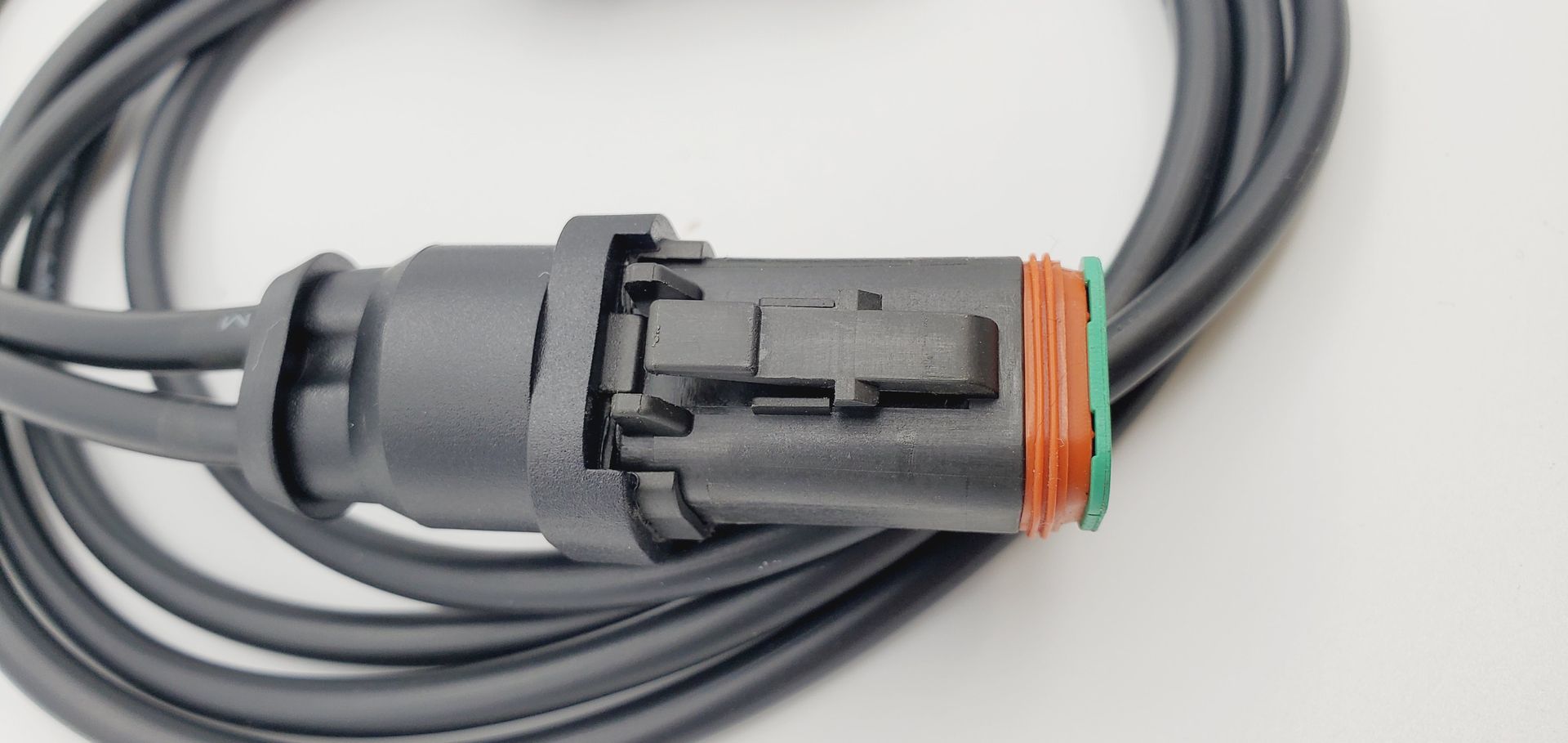 A close up of a connector on a cable on a white surface.